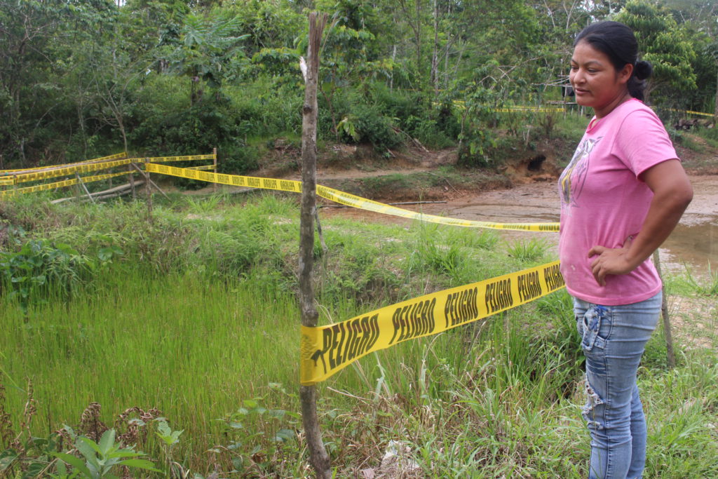 Gladys Calva, quien vive a un lado de un pantano que está remediando Amazonía Viva, muestra fosas dentro de su propiedad que siguen contaminada con pasivos ambientales.